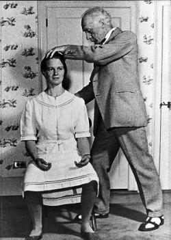 Photograph of Frederick Mathias Alexander, founder and developer of the Alexander Technique, working with a female student to help her improve h